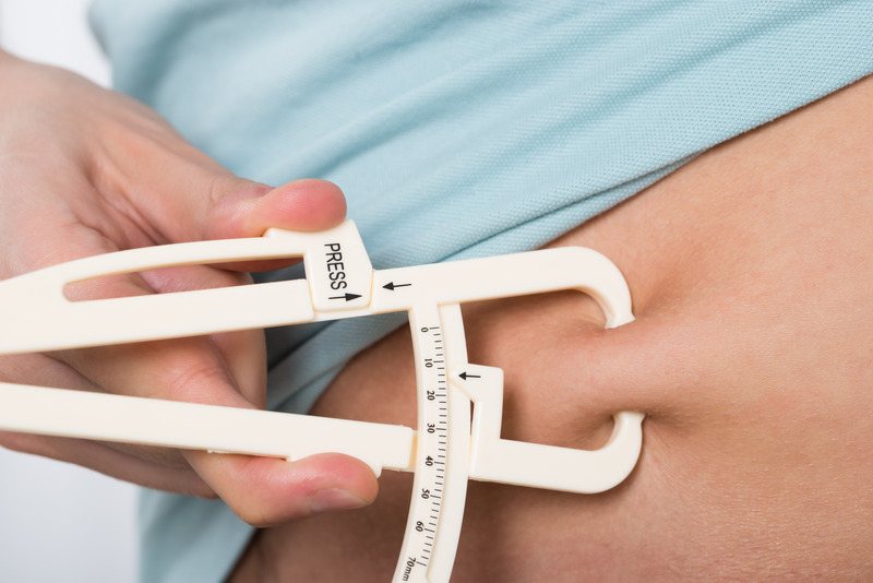 Körperfettmessung mit einem Caliper an der Taille